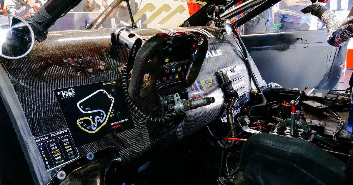 Detailed view of a racing car's cockpit highlighting the carbon fiber dashboard and steering wheel.