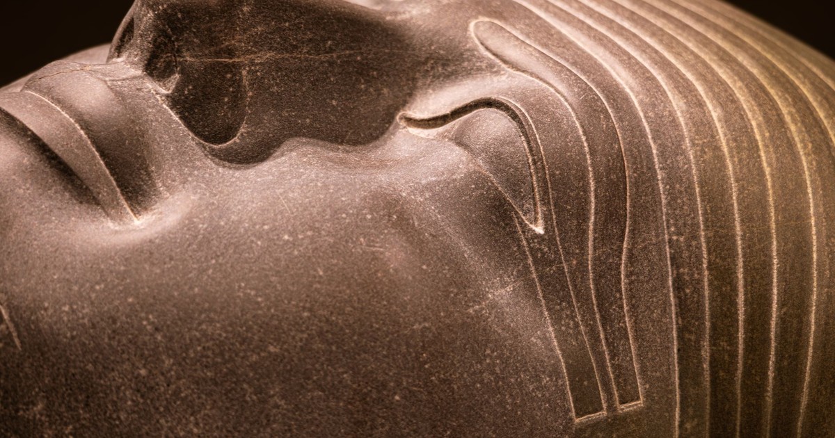 Detailed close-up of an ancient Egyptian statue head with intricate carvings.