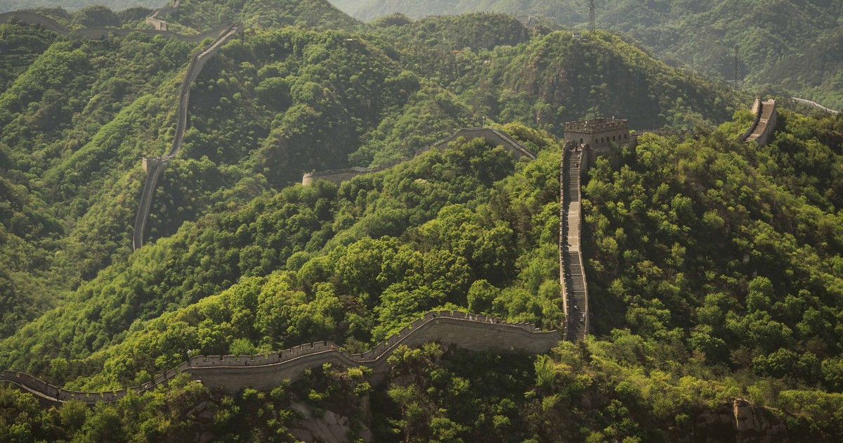 A breathtaking aerial view of the iconic Great Wall of China winding over lush green hills in Beijing.