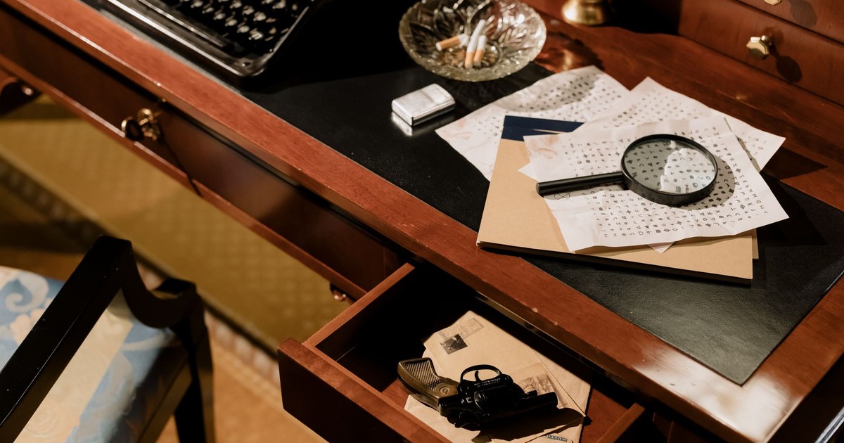 A moody vintage detective's desk with typewriter, magnifying glass, and secret documents.