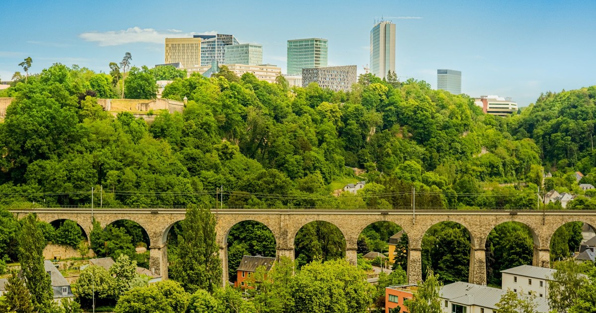 A picturesque view of Luxembourg City featuring a historic viaduct and modern skyline.
