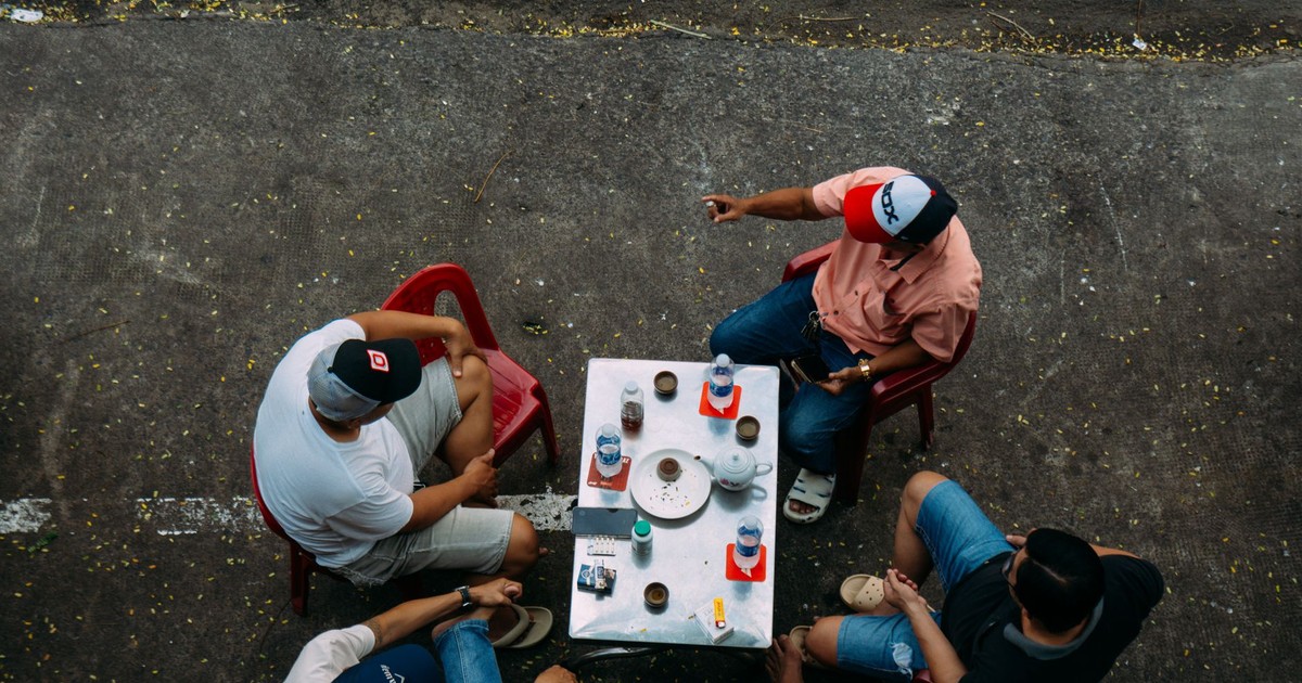 Overhead view of friends enjoying a casual outdoor coffee gathering.