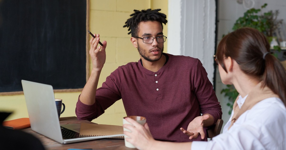 Two colleagues engaged in a collaborative discussion during a team meeting at the office.