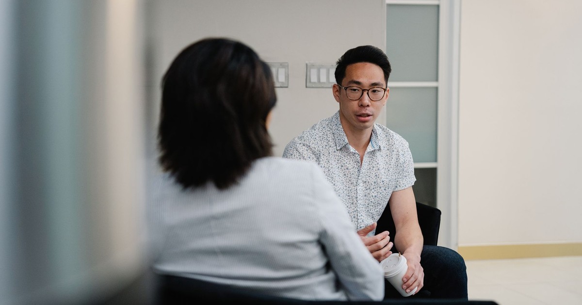 Two colleagues having a focused conversation in an office setting.