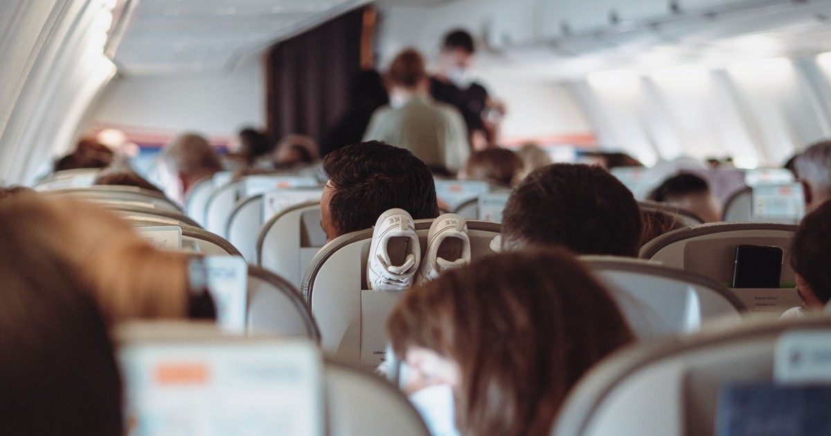 View of passengers wearing masks and seated in economy class during flight.