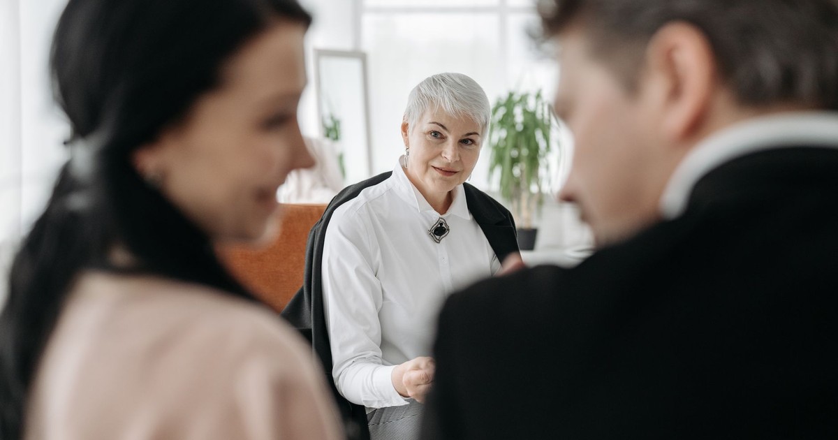 A professional consultation session with a couple and a social worker in a modern office environment.