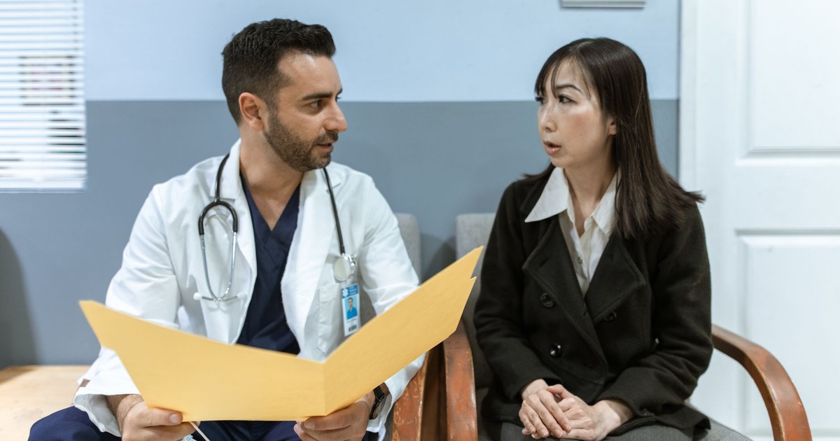 Healthcare professional consults patient in clinical setting. Medical discussion and diagnosis.