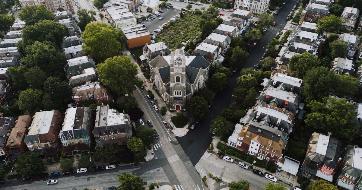 Drone shot capturing a scenic Philadelphia neighborhood with a prominent church at the center.