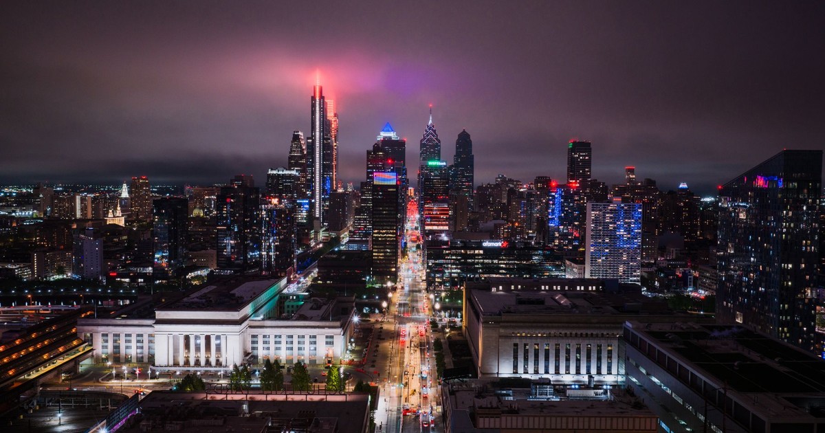 Stunning aerial view of Philadelphia's illuminated skyline at night, showcasing vibrant city lights.