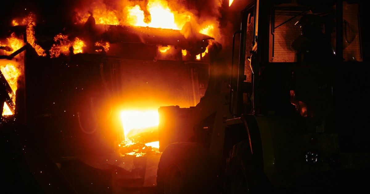A dramatic scene of an industrial fire blazing fiercely at night.
