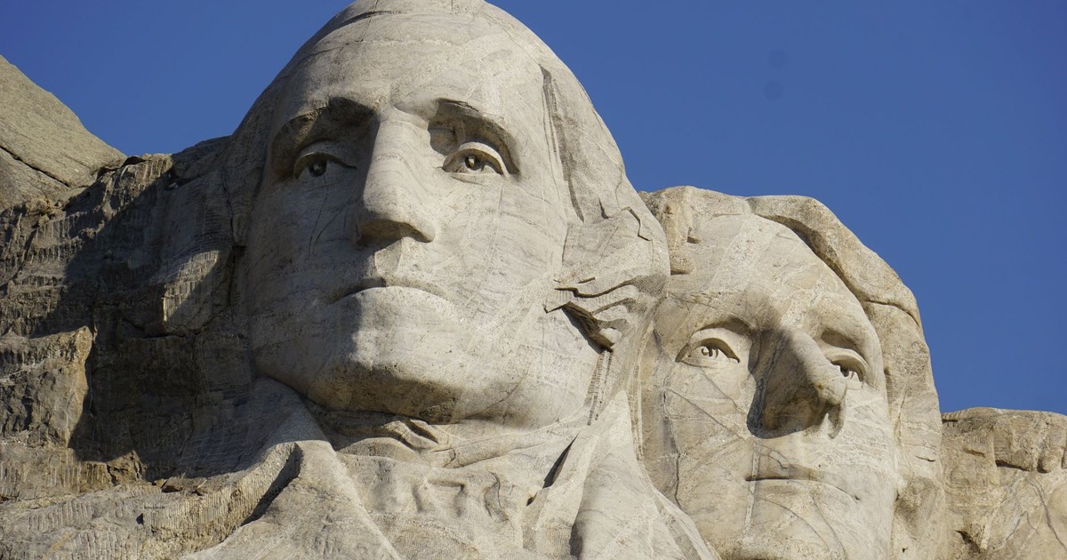 A detailed close-up shot of Mount Rushmore's iconic presidential sculptures against a clear blue sky.