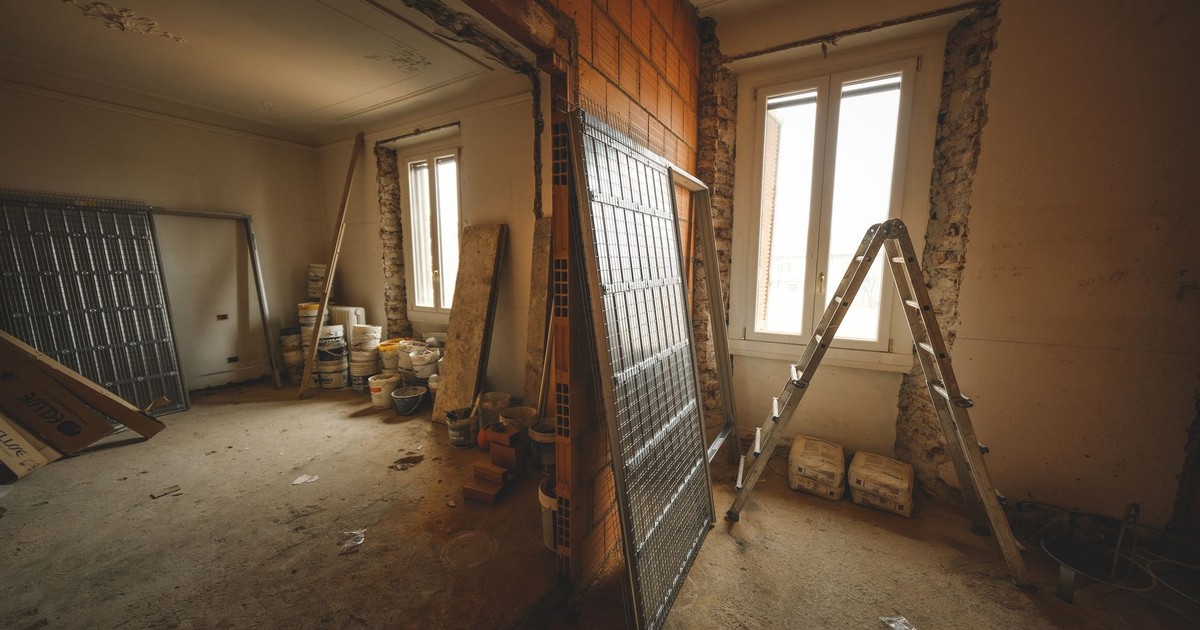 Interior view of a room under renovation with construction materials and a ladder.