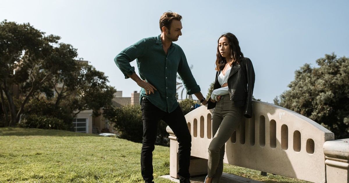 A couple in a tense discussion in a park setting, conveying relationship conflict.
