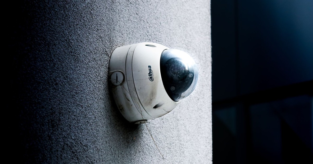 Close-up view of a dome security camera mounted on a concrete wall for surveillance.