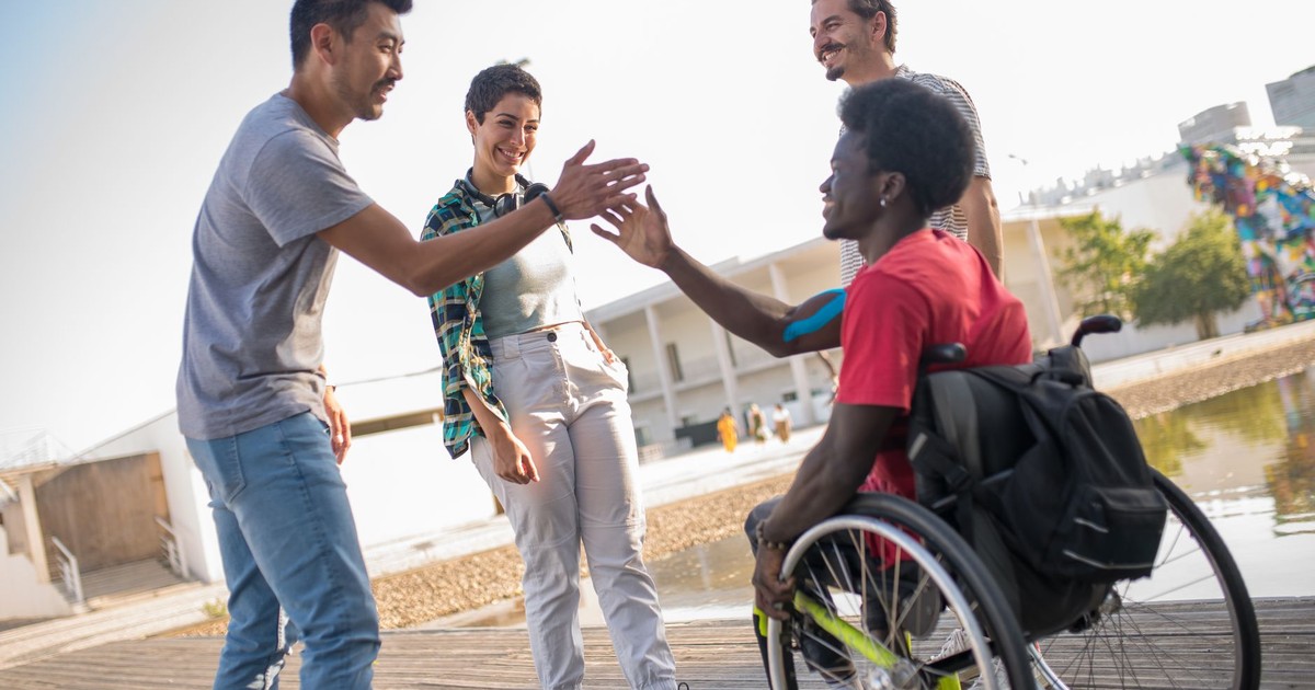 Friends greet each other outdoors in Portugal, promoting diversity and inclusion.