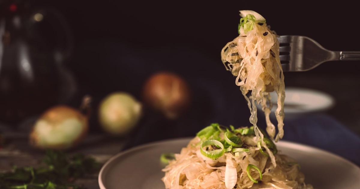 A mouthwatering plate of sauerkraut garnished with green onions, ready to eat.