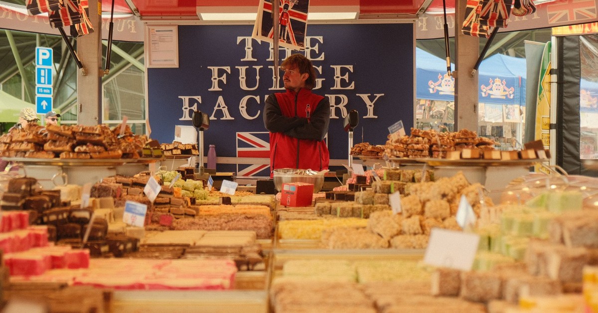 A vibrant selection of fudge displayed at an outdoor market stall, featuring British flags and signage.