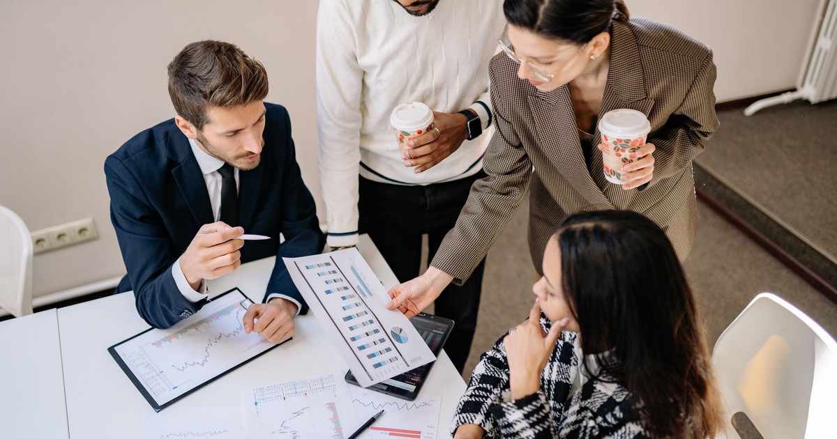 Four colleagues discuss data and strategy in an office setting.