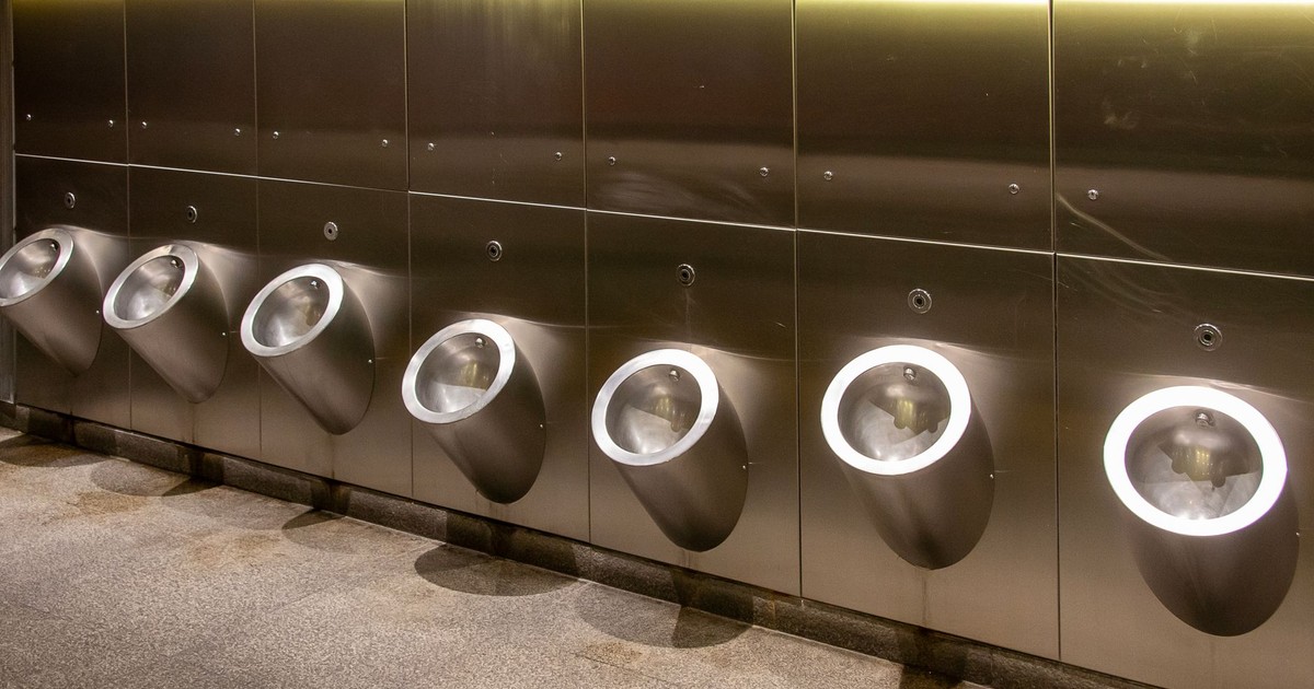 Row of modern stainless steel urinals in a public bathroom, clean and minimalistic design.