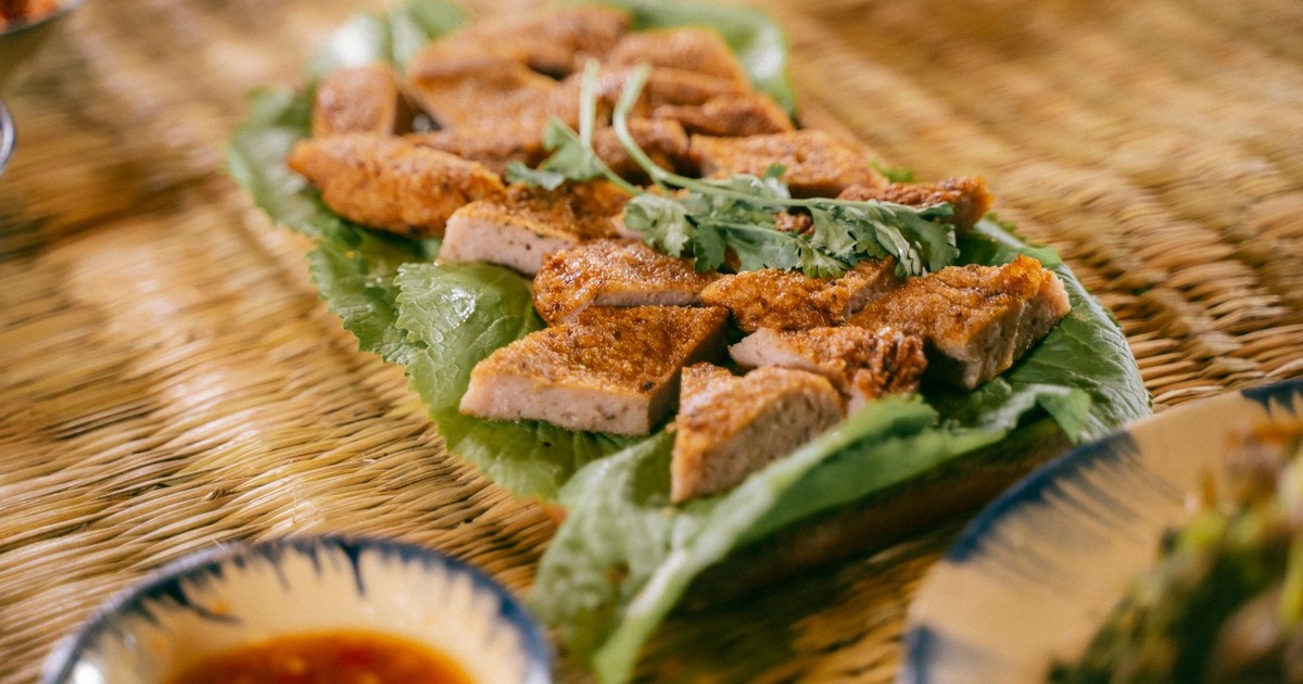 Mouthwatering crispy pork belly slices served on fresh lettuce with a garnish, perfect for a culinary delight.
