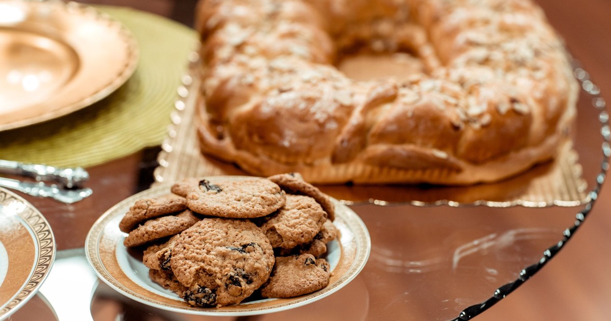 Close-up of bread with nuts and a plate of oatmeal raisin cookies on a table.