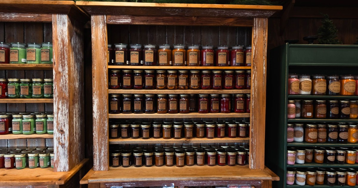 Rustic wooden shelves displaying a variety of jarred products in a cozy store setting.