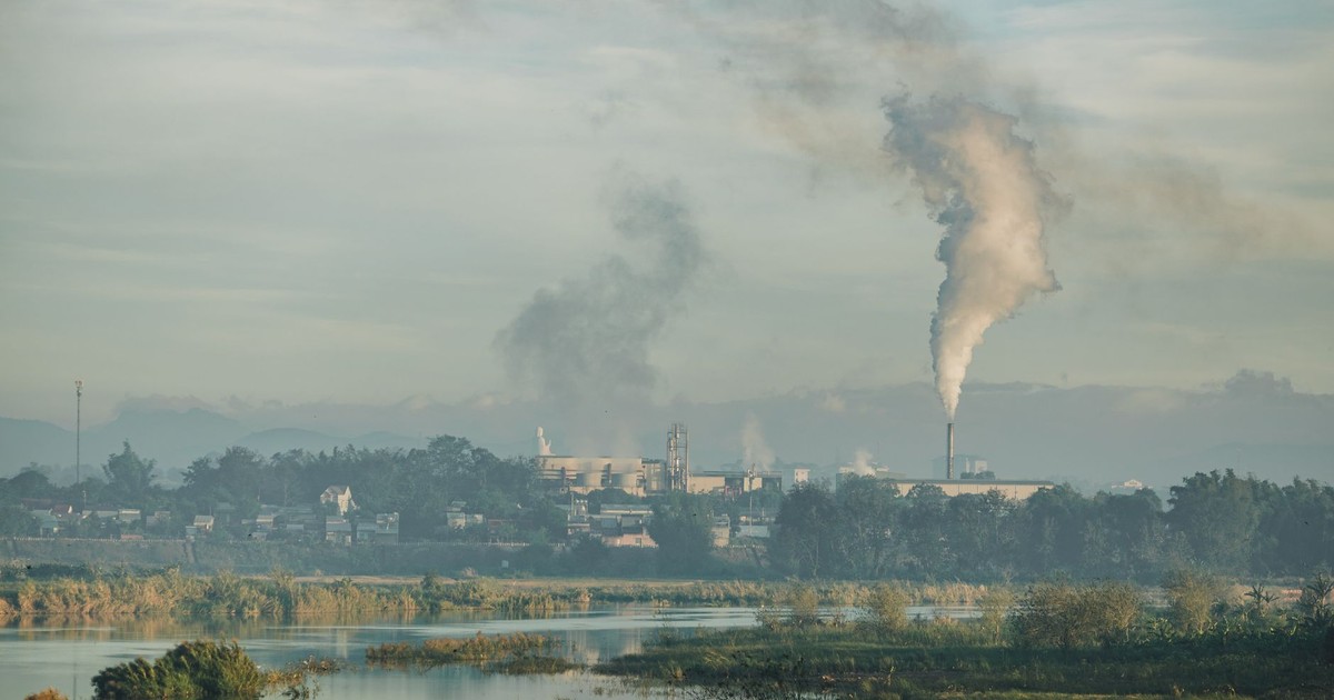 A factory emitting smoke over a natural landscape in Kon Tum, Vietnam.