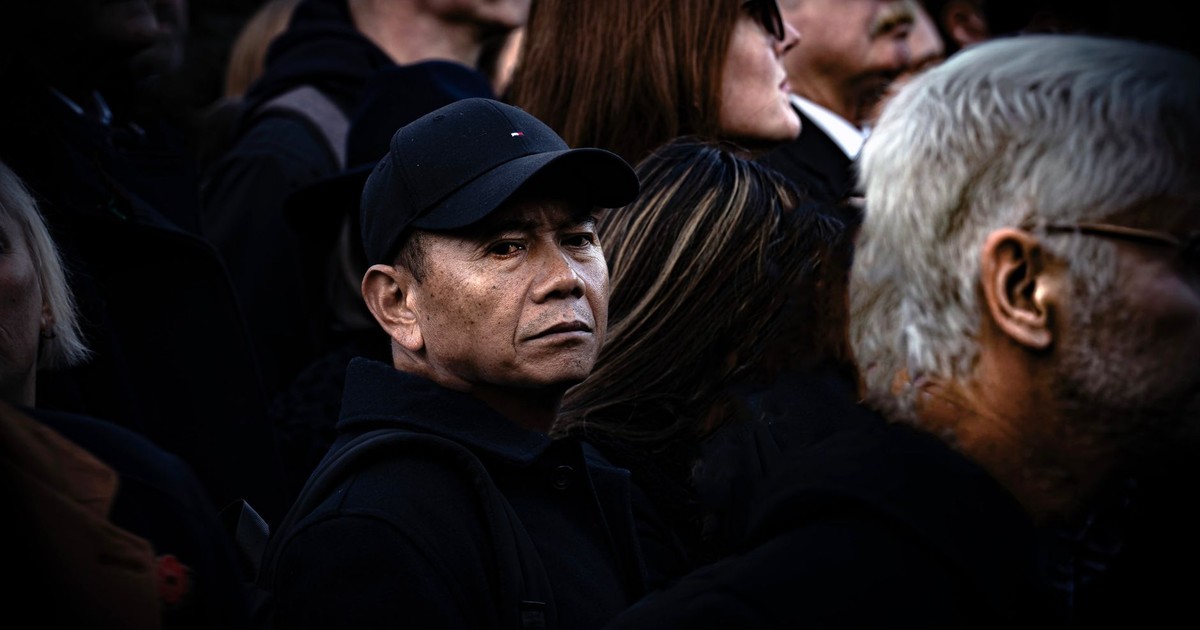 Candid street photograph capturing diverse crowd with a focus on an intense gaze from a central figure.